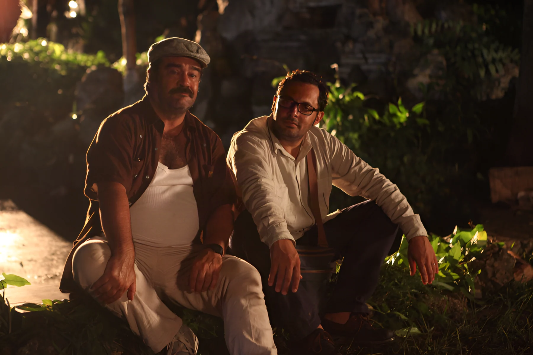 Francesco Pannofino and Enrico Brignano sitting outdoors in a night scene from Faccio un salto all’Avana.